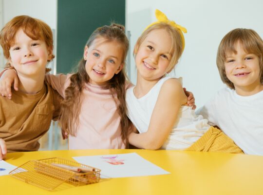 Enfants souriants et complices, illustrant la confiance en soi retrouvée